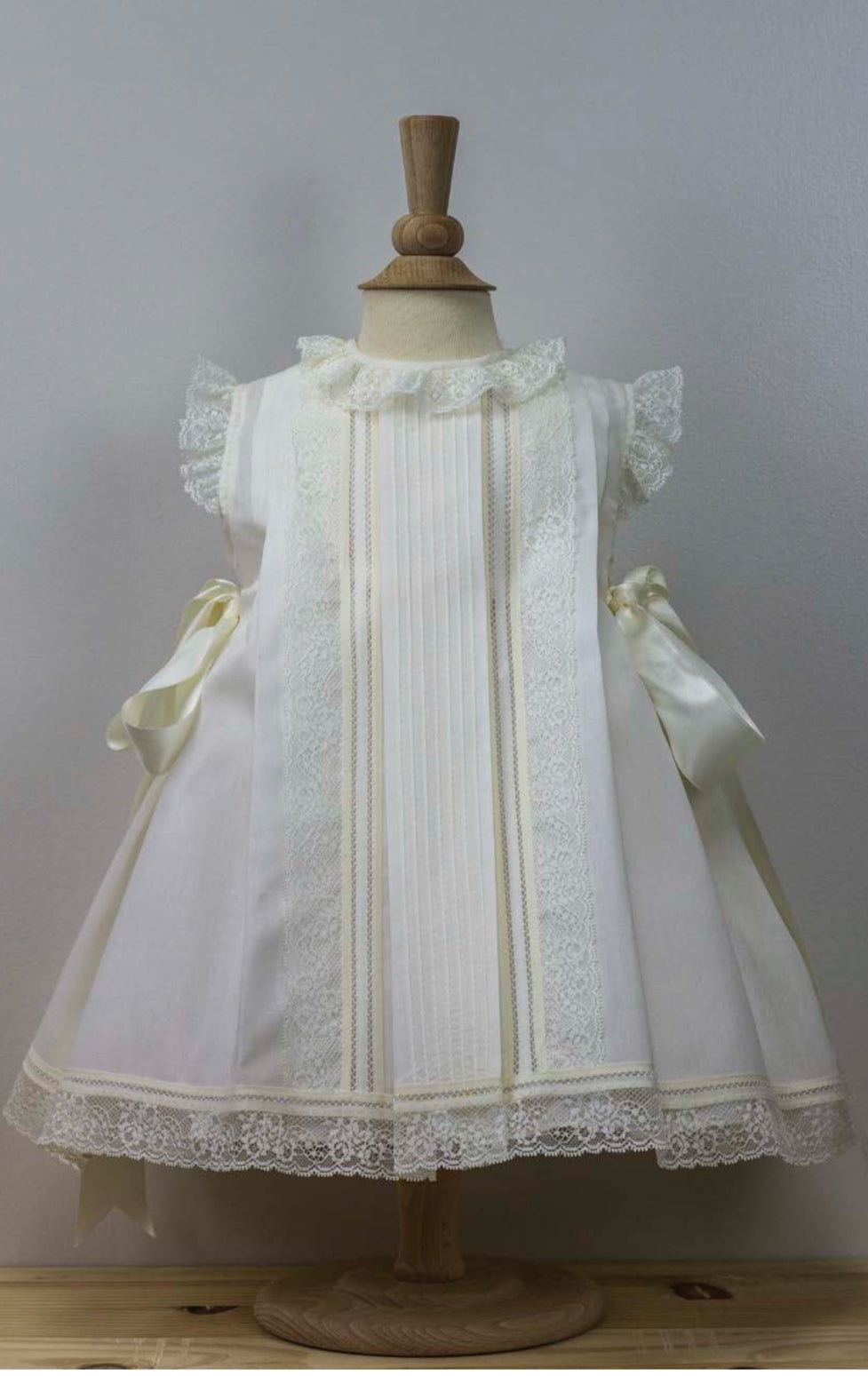 Timeless Ivory Christening Gown with Intricate Lace Trim and Bow Ties