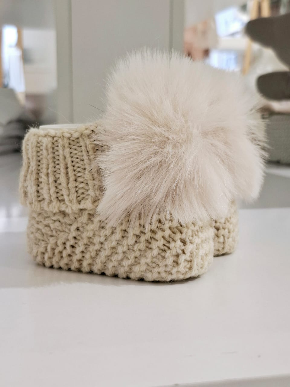 Knitted baby boots adorned with fur
