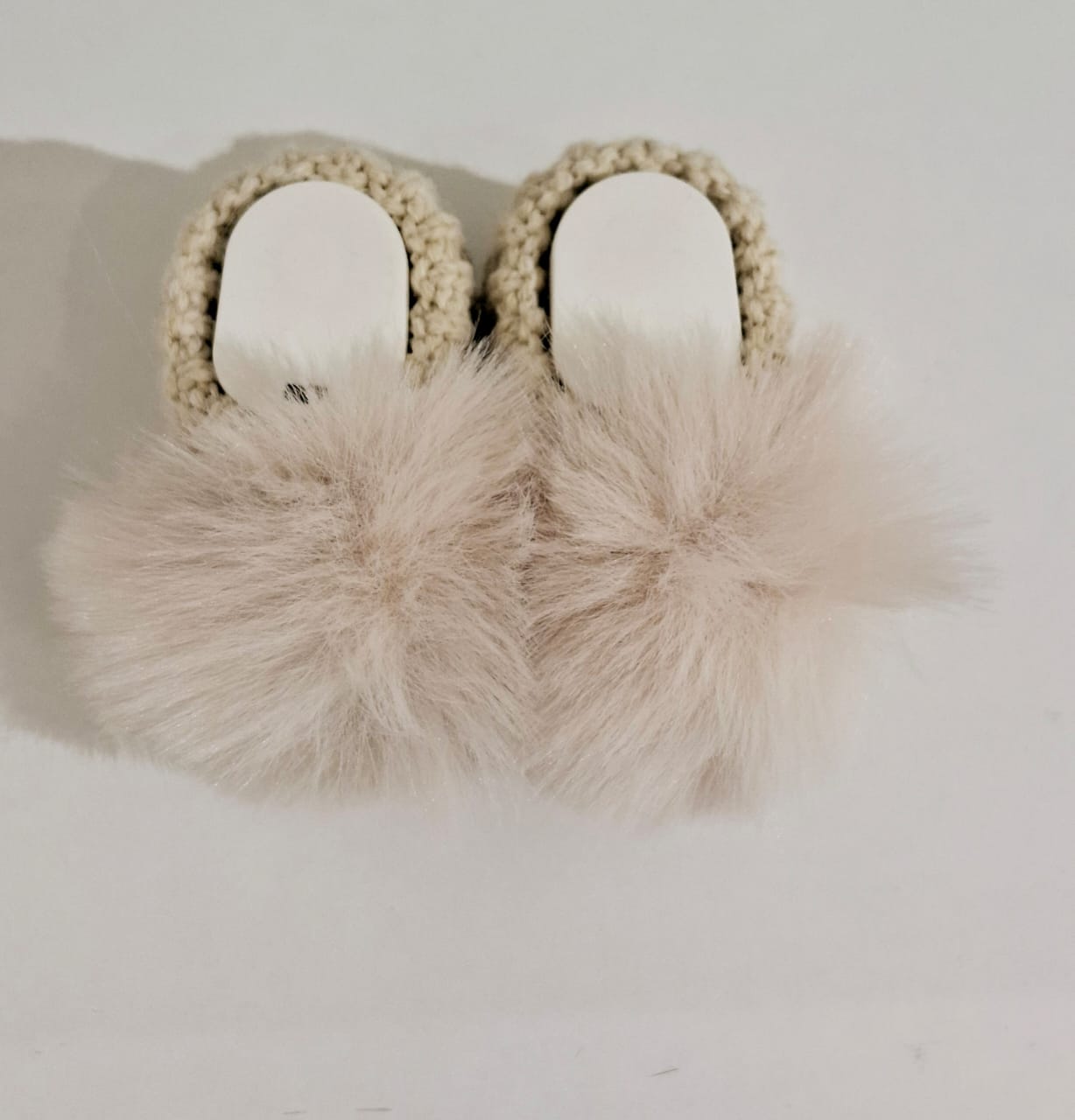 Knitted baby boots adorned with fur
