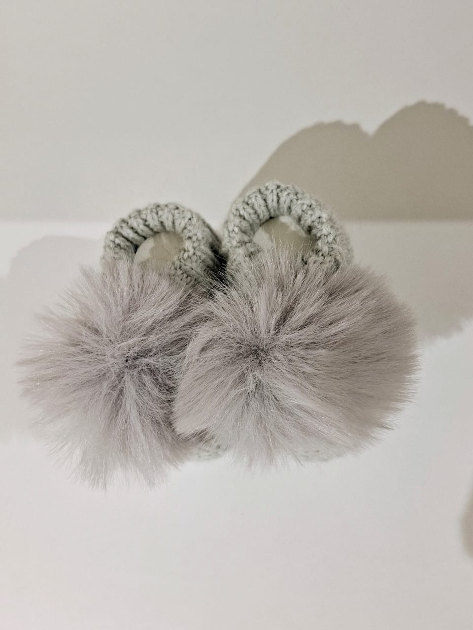 Knitted baby boots adorned with fur