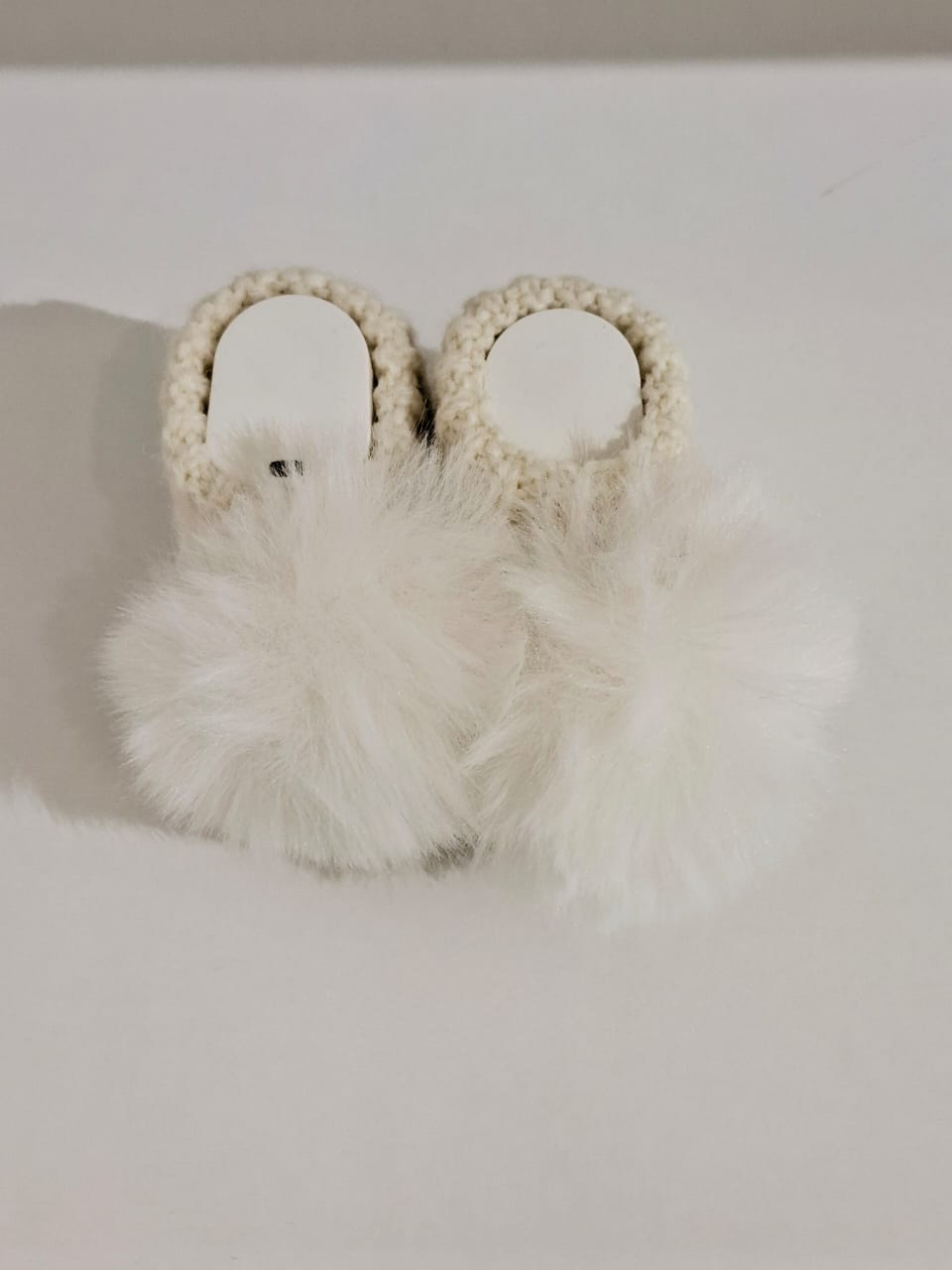 Knitted baby boots adorned with fur