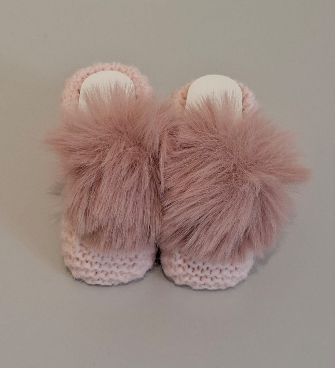 Knitted baby boots adorned with fur