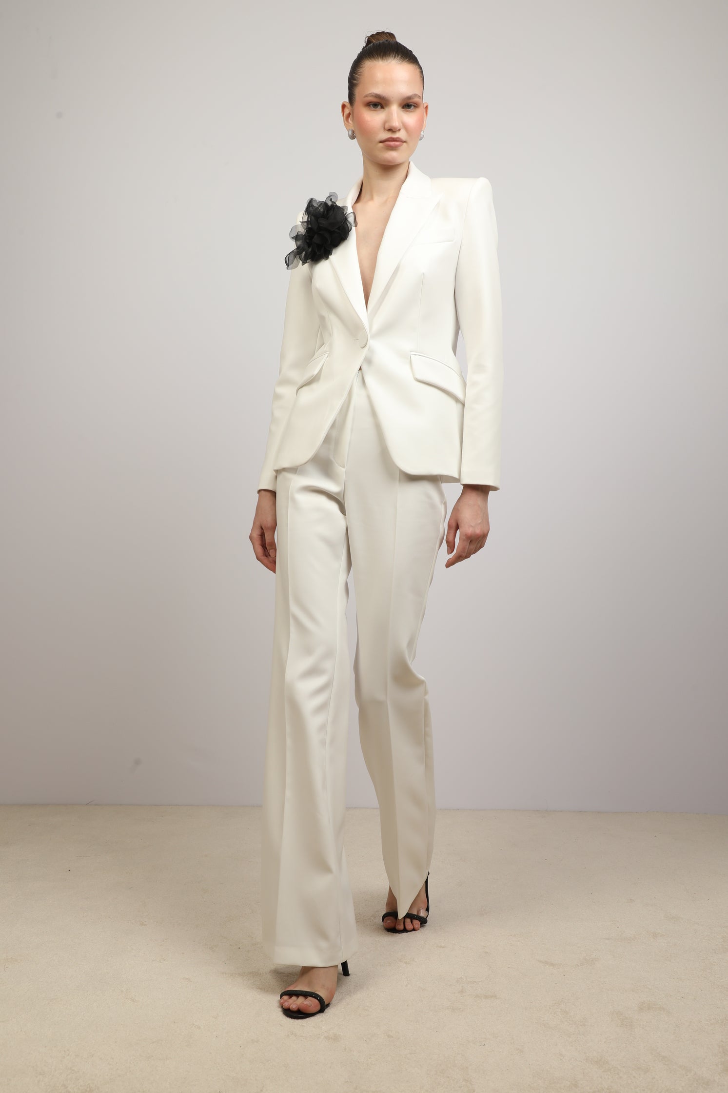 Coated blazer with flower brooch.
