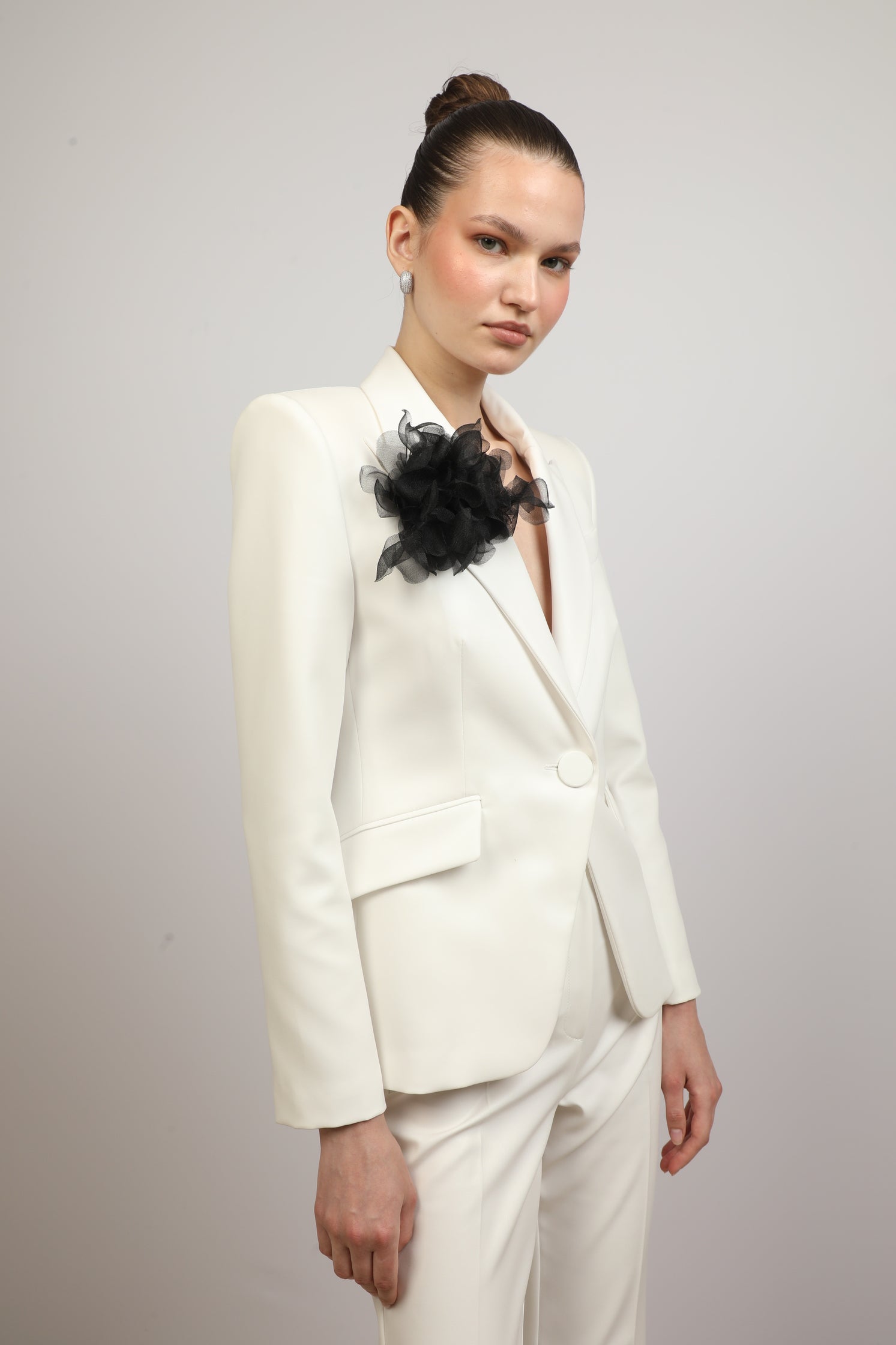 Coated blazer with flower brooch.