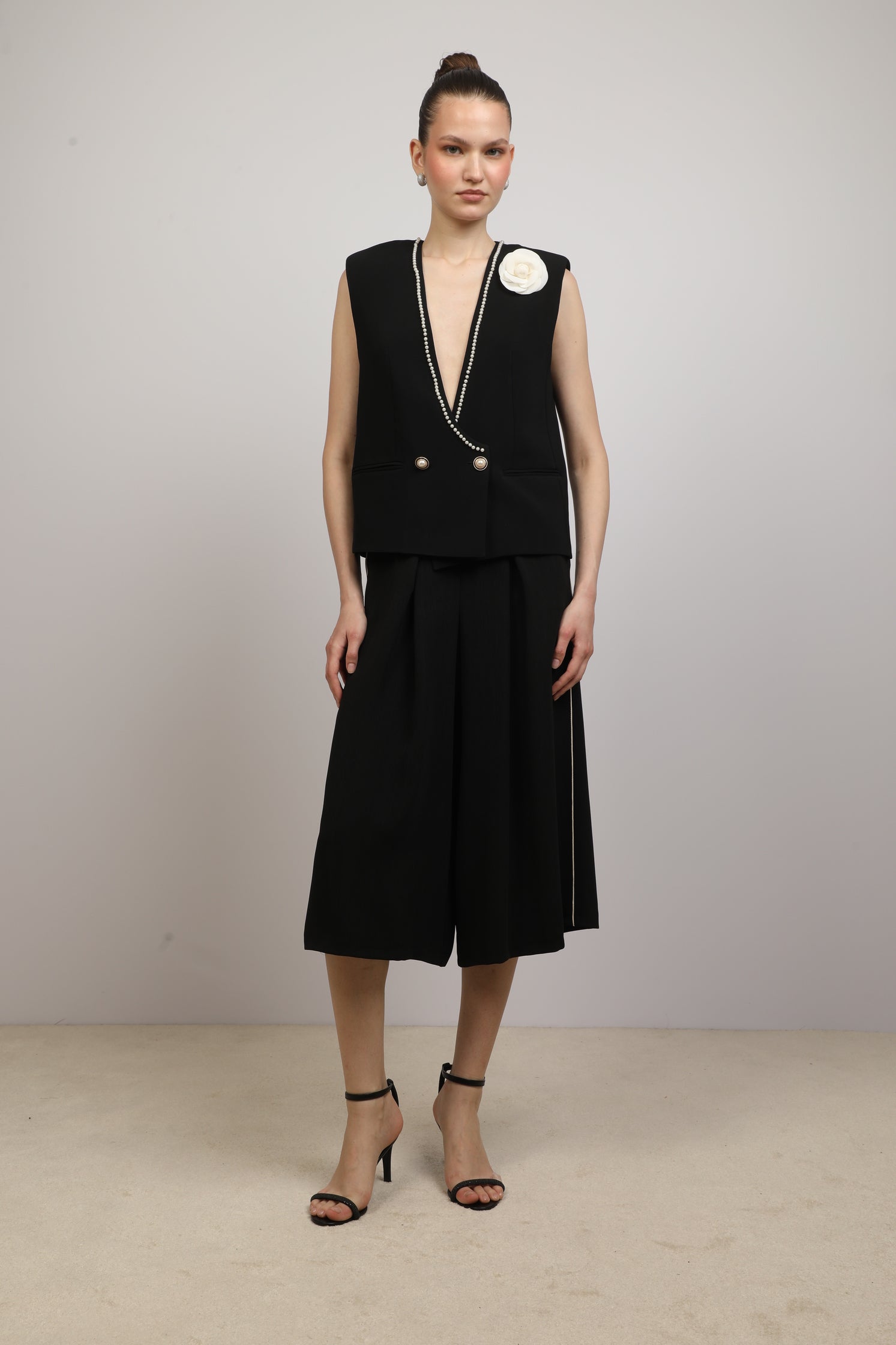 Black Vest with a flower brooch